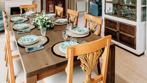 A dining room with a long table set for six, surrounded by wooden chairs with cushioned seats. - Stylish Country Cottage near Salzburg (Nußdorf am Haunsberg)