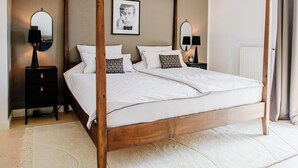 A four-poster bed with a wooden frame, white bedding, and a white rug on a wooden floor. - Stylish Country Cottage near Salzburg (Nußdorf am Haunsberg)