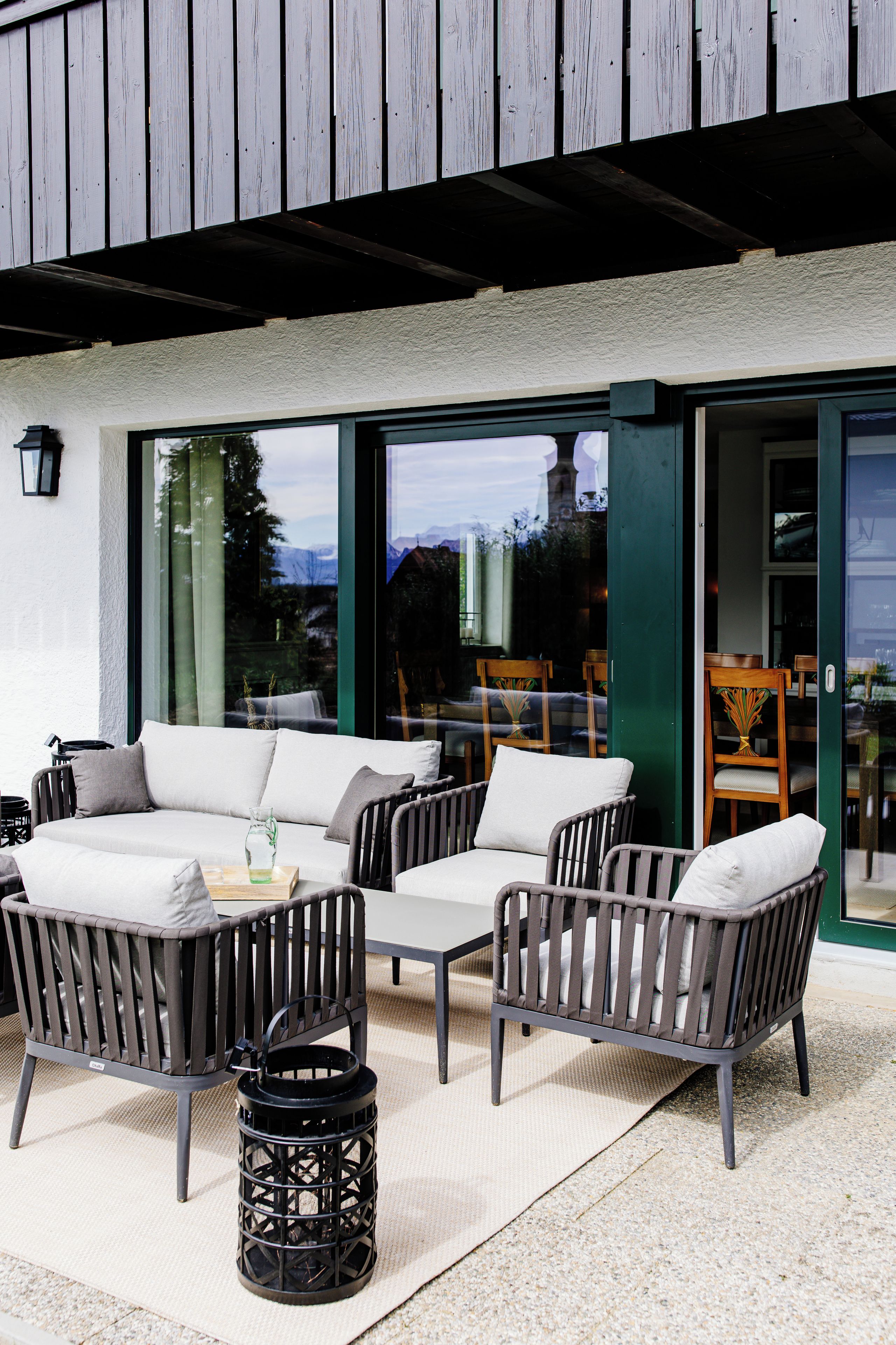 An outdoor seating area with a sofa, chairs, and a table.
