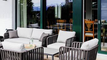 Un espace extérieur aménagé avec un canapé, des fauteuils et une table.