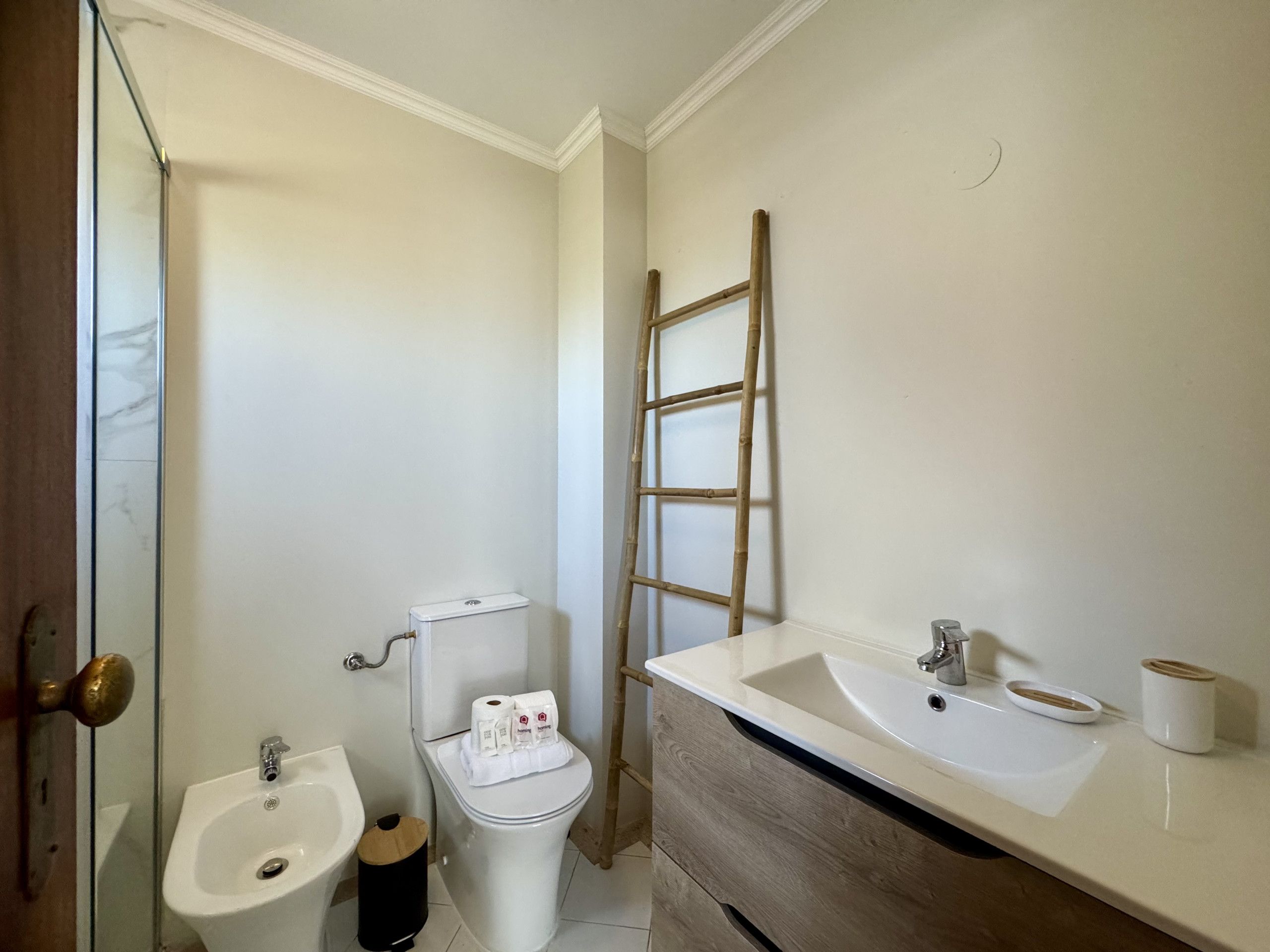 A bathroom with a toilet, bidet, and sink.