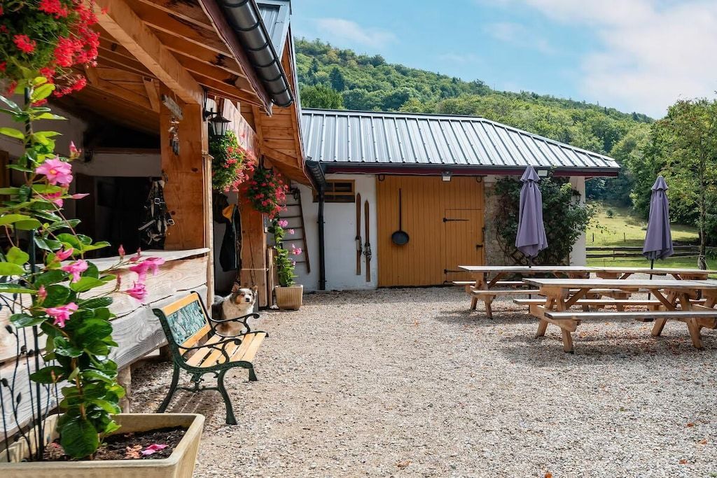 A rustic building with a wooden exterior, a gravel patio, and outdoor seating.