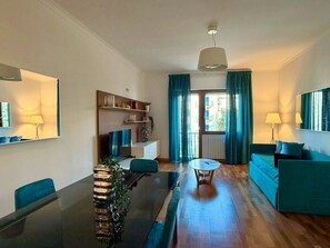 Una sala moderna con una mesa de comedor, sofá y vistas al exterior.