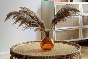 Ein Korbstuhl mit einer Vase, gefüllt mit getrocknetem Pampasgras.