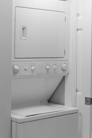 Eine weiße, kompakte Waschmaschine und Trockner-Kombination mit mehreren Bedienelementen und einer Frontlader-Türe.