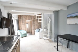 A modern interior with a kitchen area, a dining table, a spiral staircase, and a living area with a sofa and a chair. - Holiday home in Domburg with swimming pool (Domburg)
