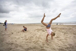 Een strand vol mensen die verschillende activiteiten ondernemen.