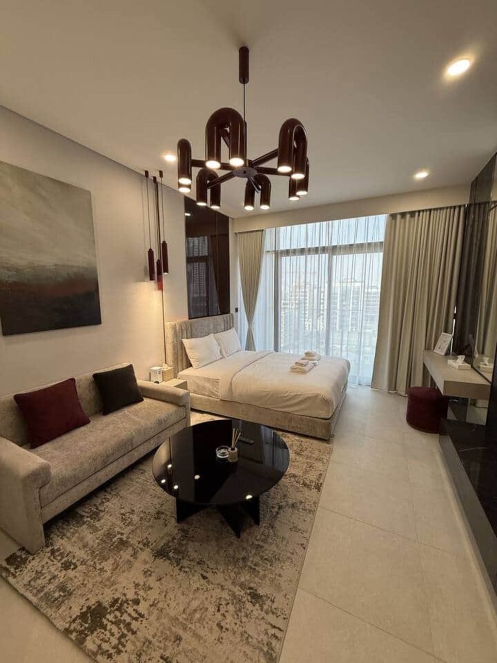 Une chambre moderne avec un grand lit, un canapé, une table basse et un bureau.