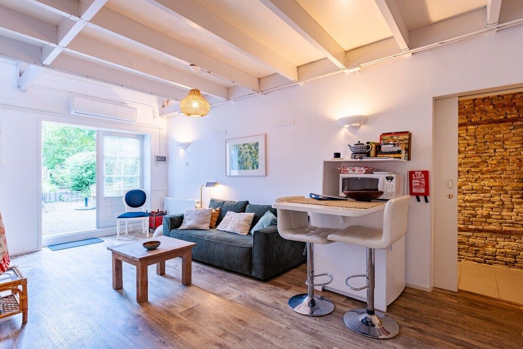A modern living room with a sofa, a coffee table, a bar area, and a stone wall.