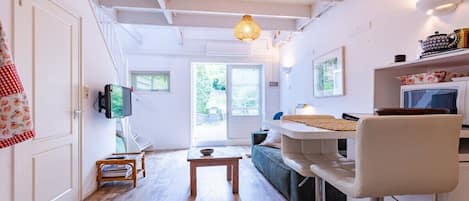 Een moderne woonruimte met een keuken, een eettafel en een bank.