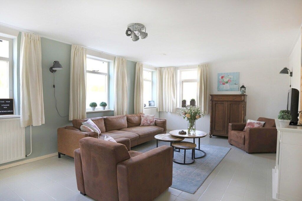 Ein Wohnzimmer mit einem braunen Sofa, einem runden Couchtisch und einem Schrank.