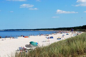 A beach with people, tents, and umbrellas. - Holiday home with 1 bedroom (Dźwirzyno)