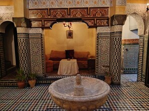 A traditional interior with a fountain, patterned walls, and a sofa. - Palais Doha & SPA (Fes)