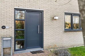 A modern building with a dark grey door, a small window, and a mailbox. - Boulevard de Wielingen 30 (Cadzand)