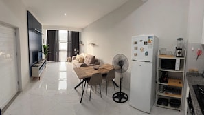 A modern kitchen with a dining area, white appliances, and a view to the outside. - AC • King Bed • Full Kitchen • Fast Wi-Fi (Praia)