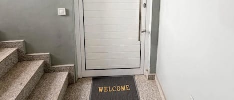 A door with a 'WELCOME' mat at the entrance.
