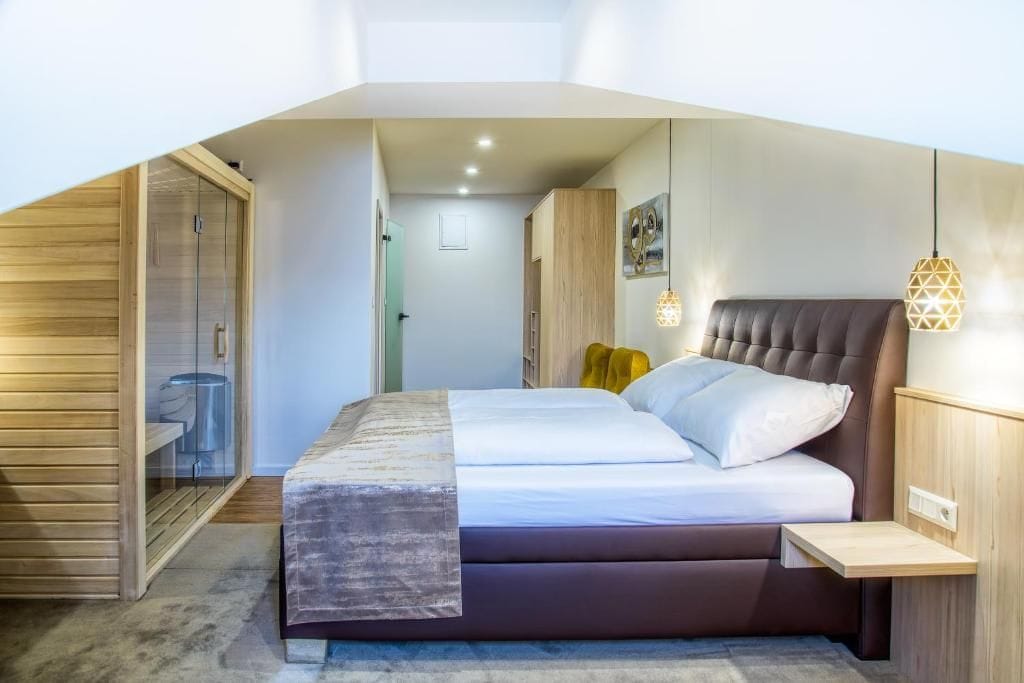 A bedroom with a bed, bedside tables, a wardrobe, and a hanging light fixture.