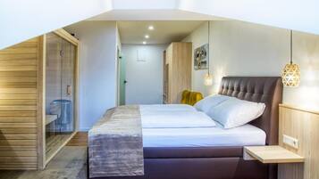A bedroom with a bed, bedside tables, a wardrobe, and a hanging light fixture.