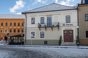 A building with a sign for 'Berg Pension' on the facade, a balcony with a railing, and a no parking sign. - Penzión Berg (Kezmarok)