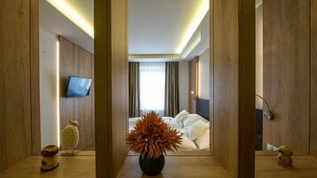 Una habitación de hotel con una cama, un televisor y un florero con flores.