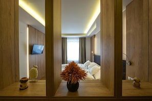 A hotel room with a bed, a television, and a vase of flowers. - Penzión Berg (Kezmarok)