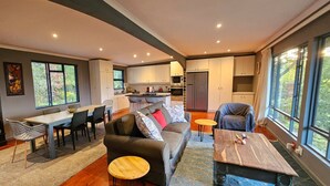 A modern living space with a kitchen, dining area, and seating. - Off-grid, luxury river-view  with private nature trails & hot tub Sedgefield (Sedgefield)