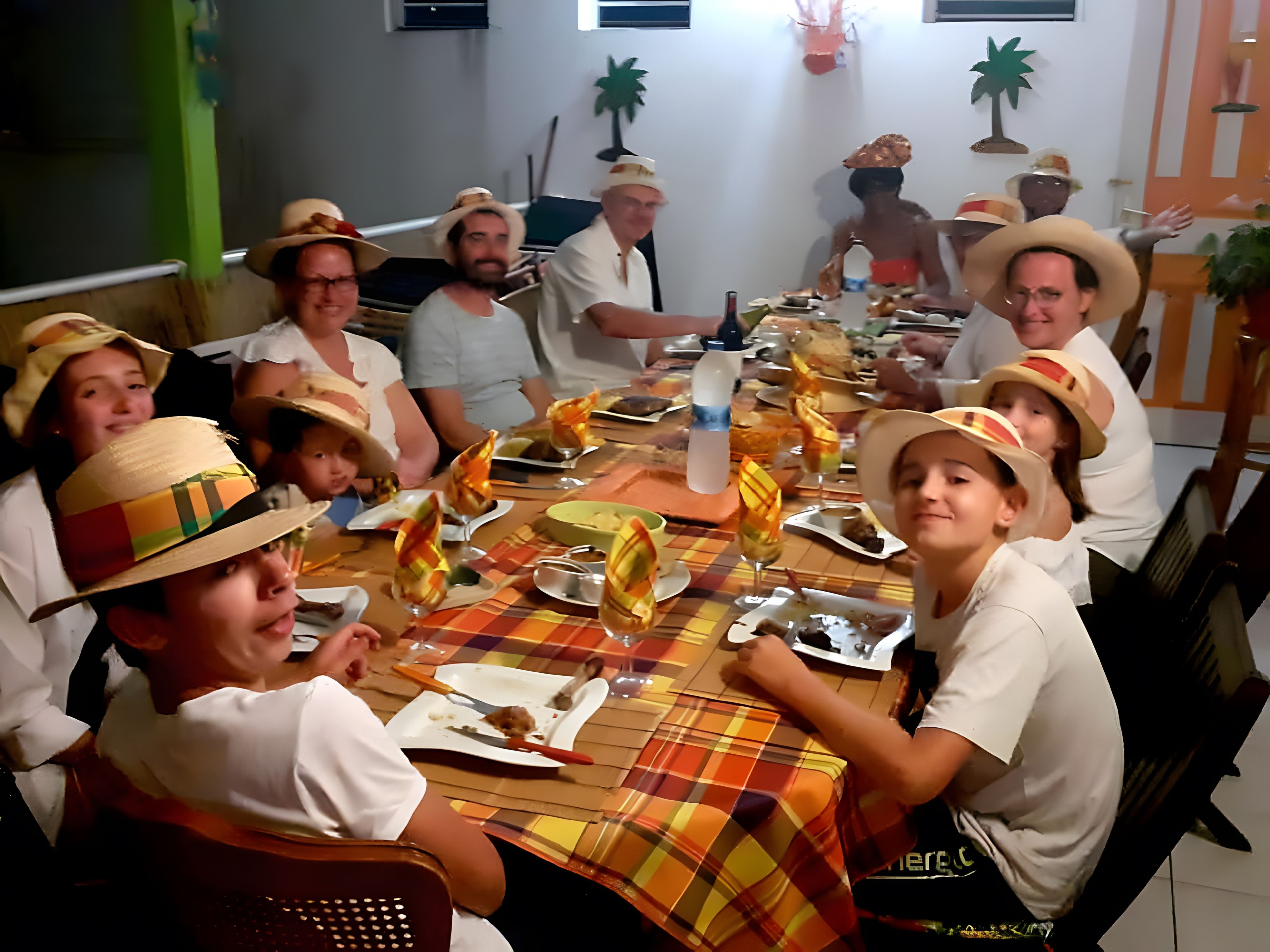 Un grupo de personas sentadas alrededor de una mesa con mantel escocés, disfrutando de una comida.