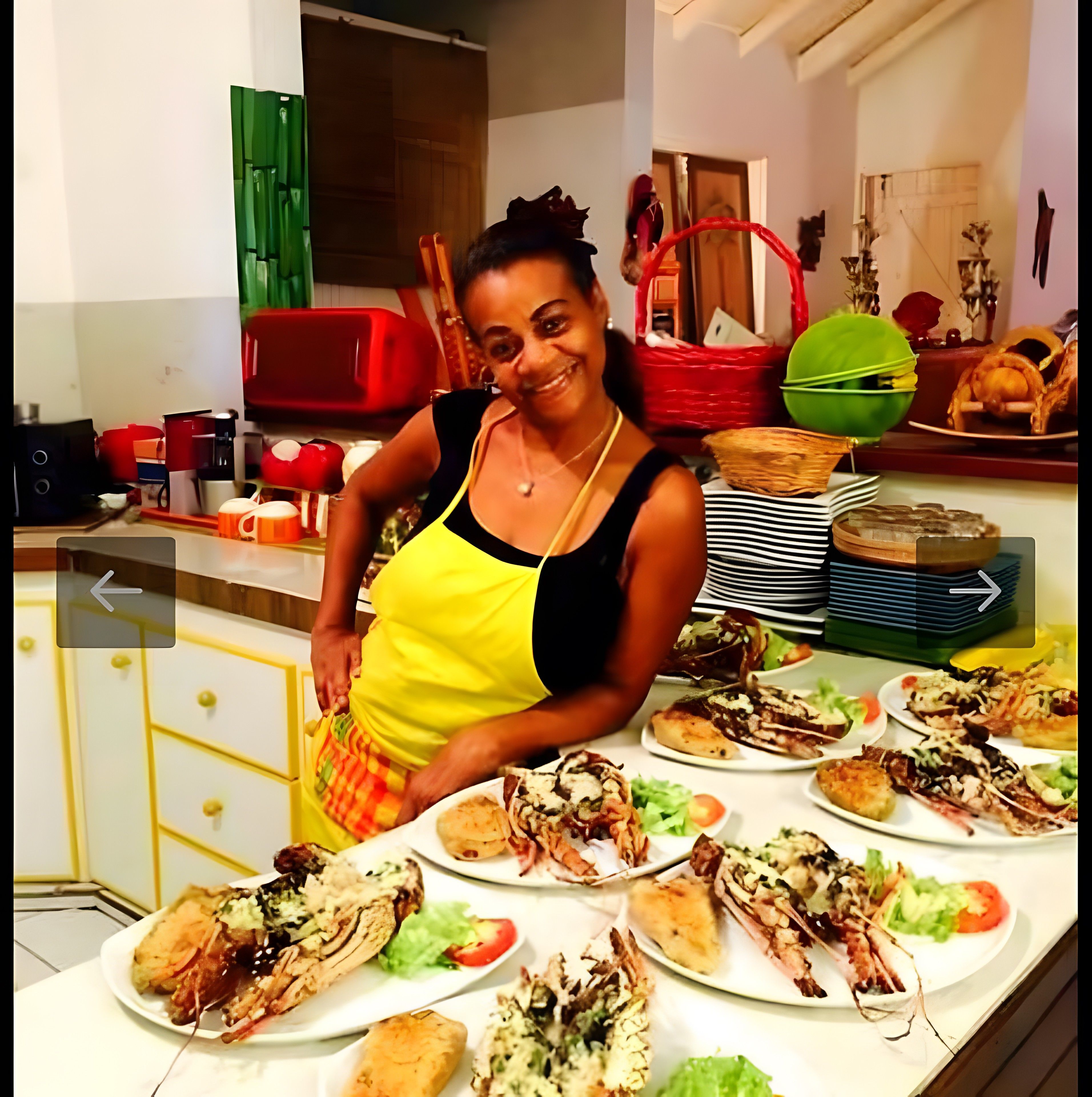 Une personne se tient dans une cuisine, et divers plats sont disposés sur le comptoir.