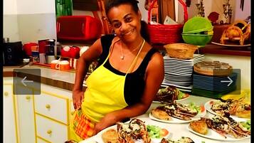 Une personne se tient dans une cuisine, et divers plats sont disposés sur le comptoir.