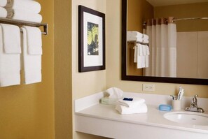 A hotel bathroom with a sink, mirror, towels, and toiletries. - 2 Full Beds | Non-Smoking, Kitchen (Rochester NY)