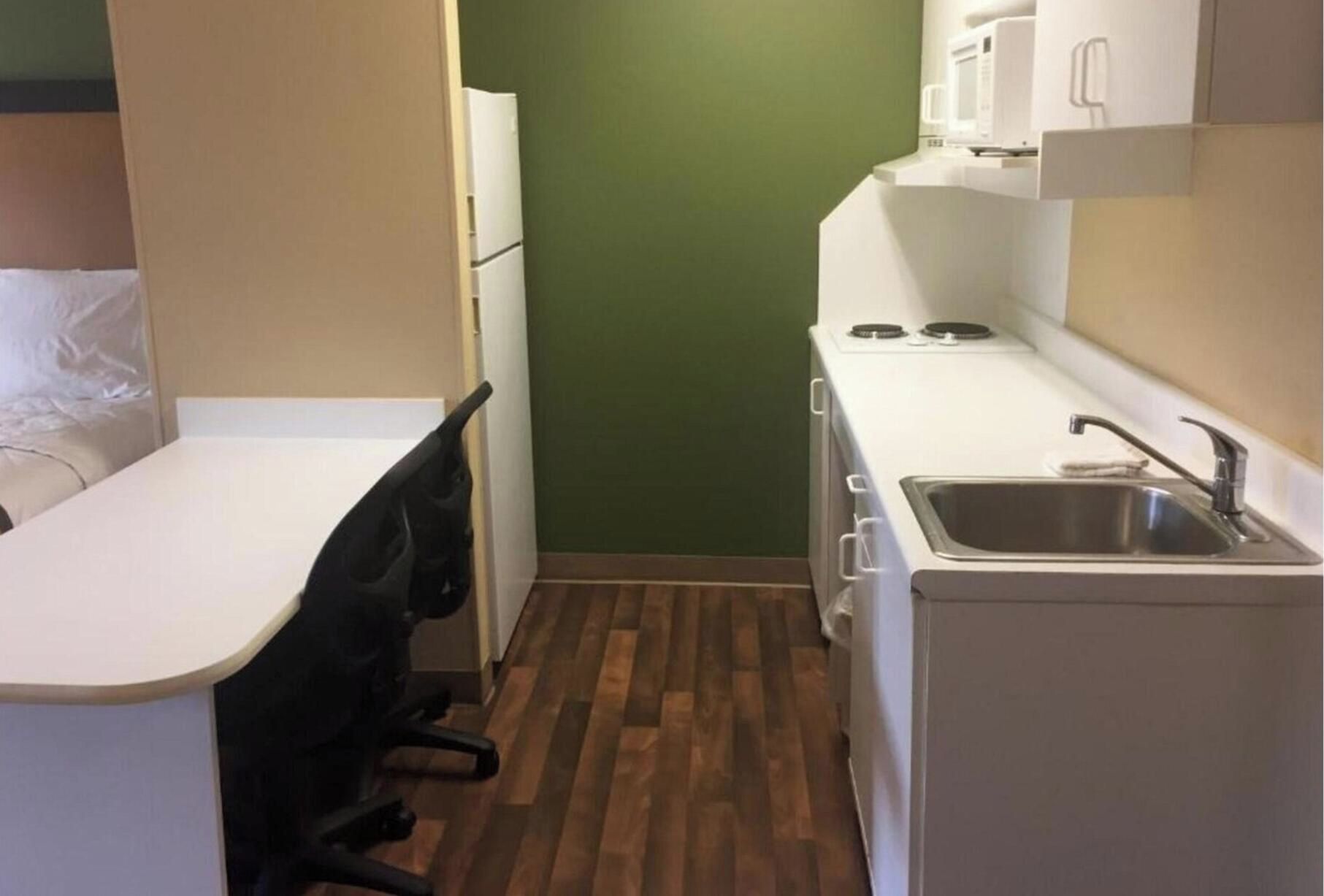Una kitchenette compacta con microondas, estufa y pileta.