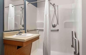 A bathroom with a sink, mirror, shower, and grab bars. - 1 Full Bed | Non-Smoking, Kitchen (Cincinnati OH)