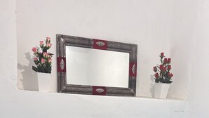 A bedroom with two beds, a dresser, a mirror, and a small shelf with flowers. - DAR LALLA KHADIJA (RABAT)