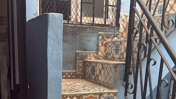 A staircase with patterned tiles leading to a door with a keyhole.