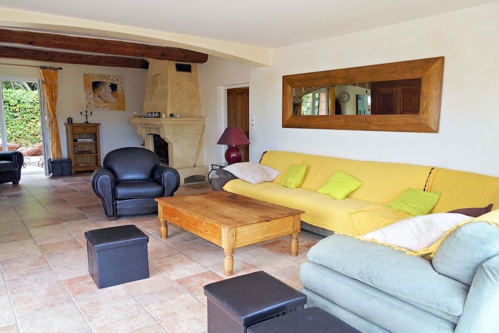 Ein Wohnzimmer mit einer Couch, Sesseln, einem Couchtisch und einem Kamin.