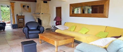 Ein Wohnzimmer mit einer Couch, Sesseln, einem Couchtisch und einem Kamin.