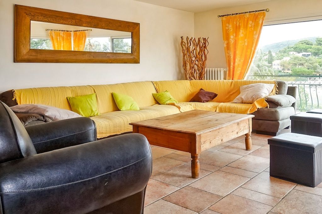 Ein Wohnzimmer mit einer Couch, einem Couchtisch und Blick ins Freie.