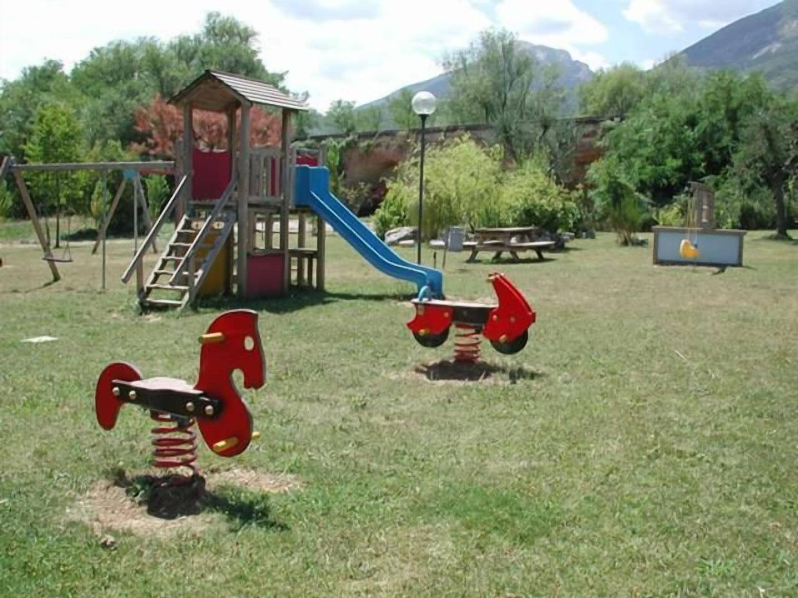 Un parque infantil con un tobogán y columpios.