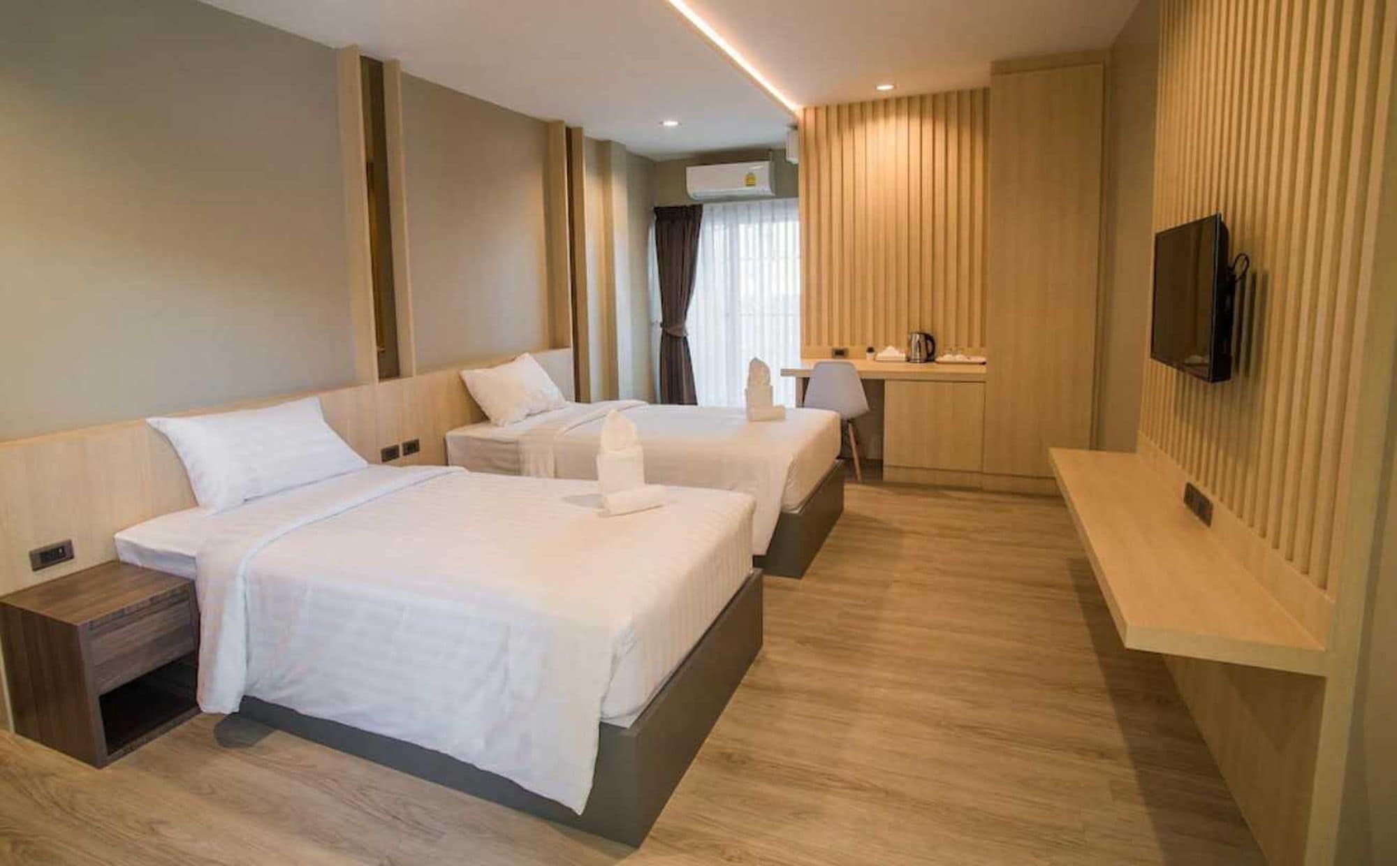 Une chambre d’hôtel avec deux lits, un bureau, une télévision et une salle de bain.