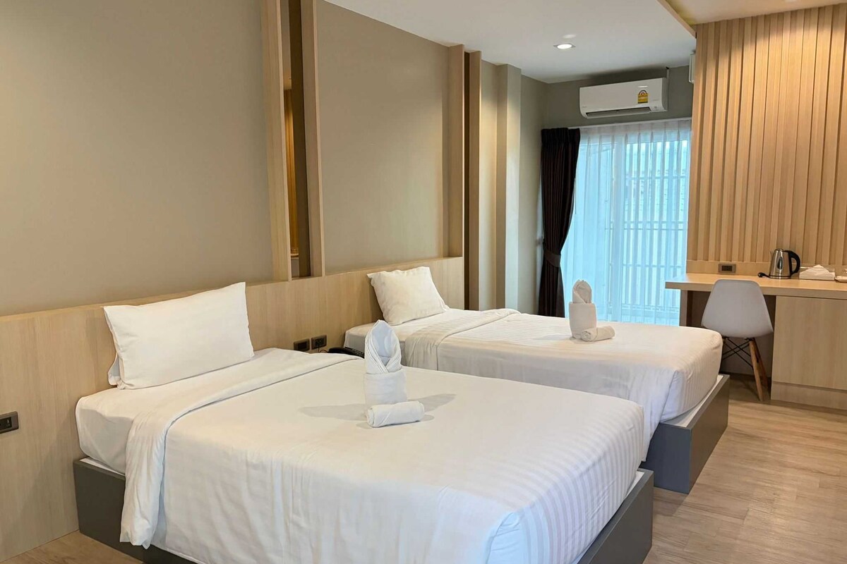 Una habitación de hotel con dos camas, un escritorio y una silla.