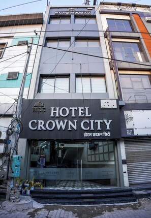 Exterior del Hotel Crown City con fachada moderna, amplias ventanas y una entrada visible.