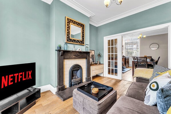 Una sala de estar con chimenea, televisor y sofá.