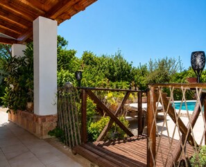 A wooden deck with a pool, surrounded by lush greenery and a clear blue sky. - A Private Oasis in Nature | Pool + Hot Tub (Málaga)
