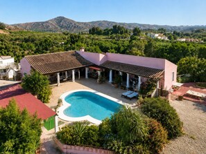 A villa with a swimming pool, outdoor seating, and a view of the surrounding hills. - A Private Oasis in Nature | Pool + Hot Tub (Málaga)