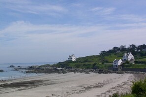 A coastal landscape with two white houses on a grassy hill, a sandy beach, and rocky outcrops. - Brittany / Locquirec (Locquirec)