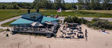 A beachside building with a covered seating area and a flag.