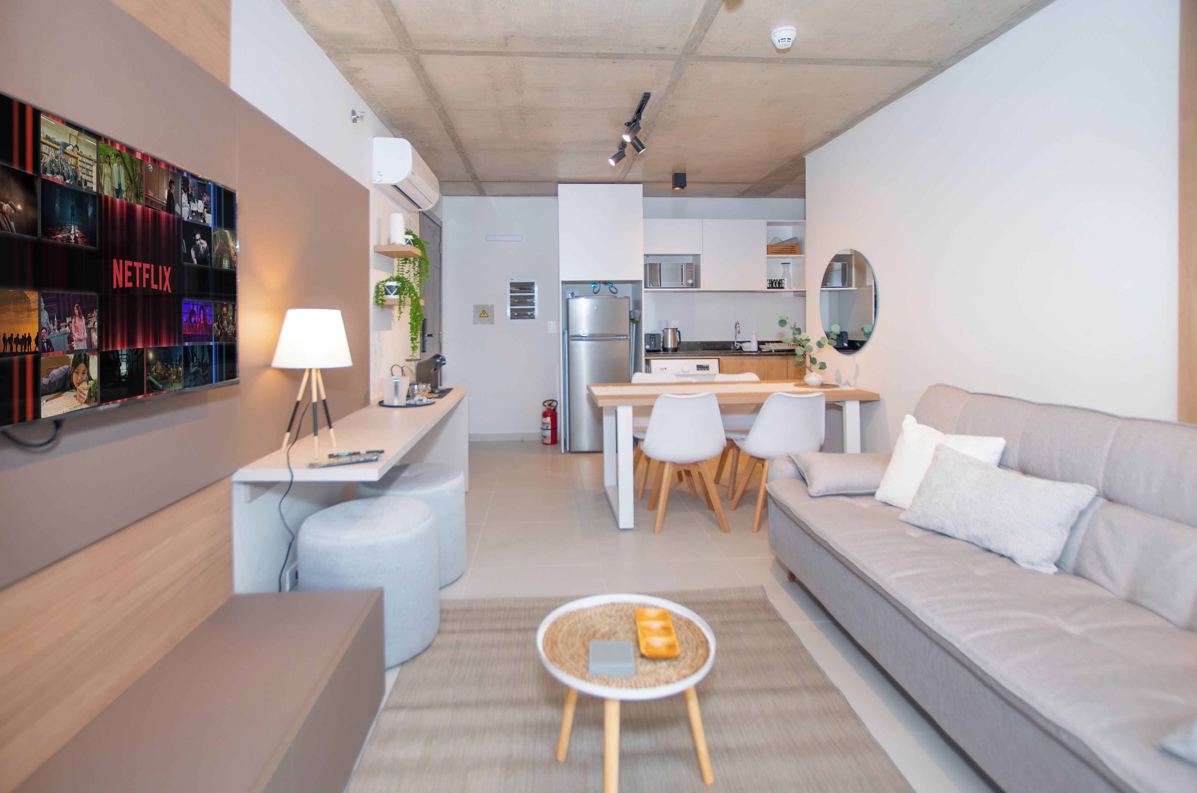 Ein modernes Wohnzimmer mit einer Couch, einem Couchtisch und einer TV-Wand mit Netflix-Branding.