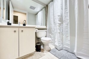 Een badkamer met een toilet, een wastafel en een spiegel.
