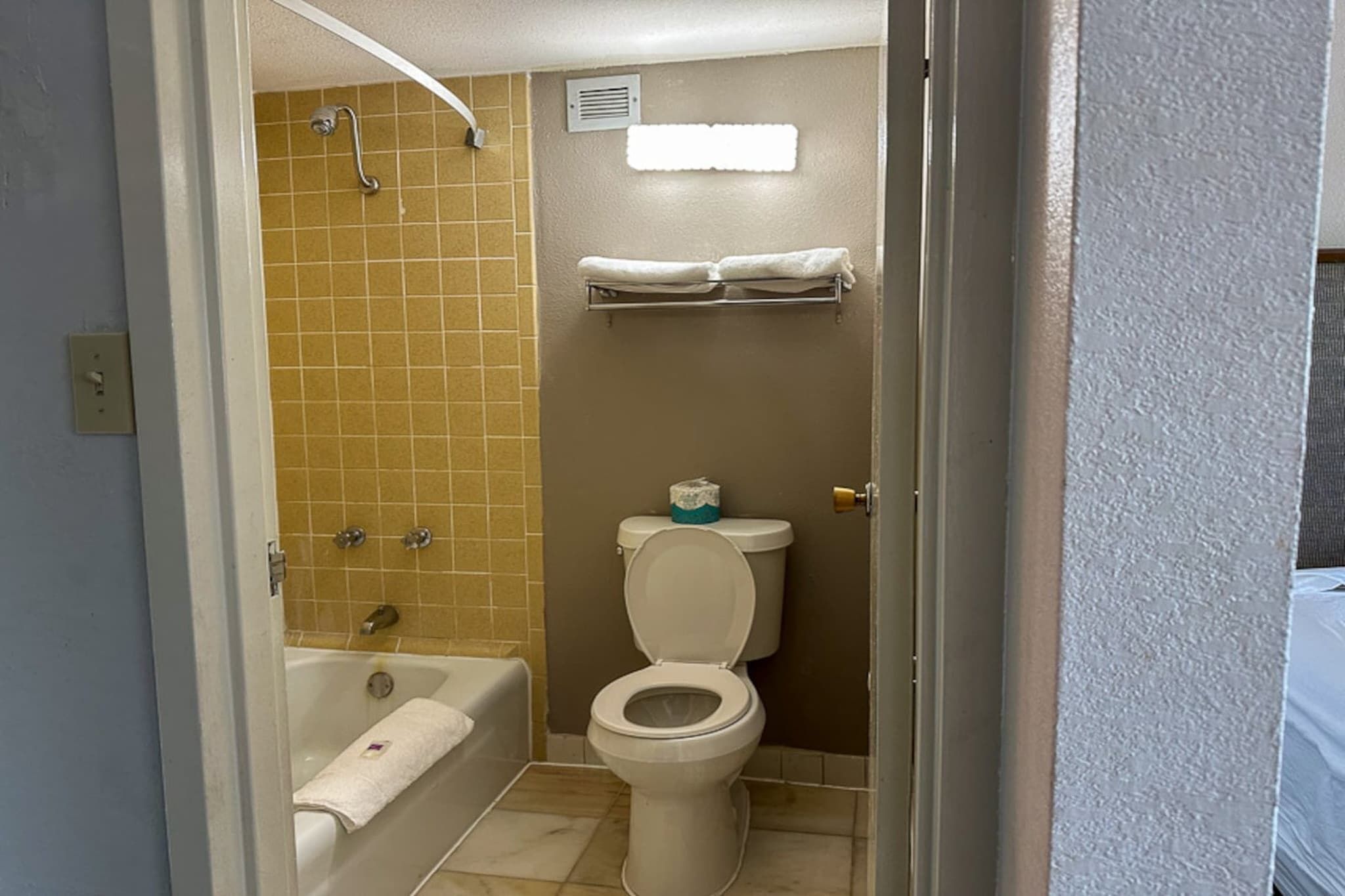 A bathroom with a bathtub, toilet, and a shower area.