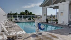 A swimming pool with lounge chairs and a lifeguard stand. - 1 QUEEN BED | NON-SMOKING (The Dalles)